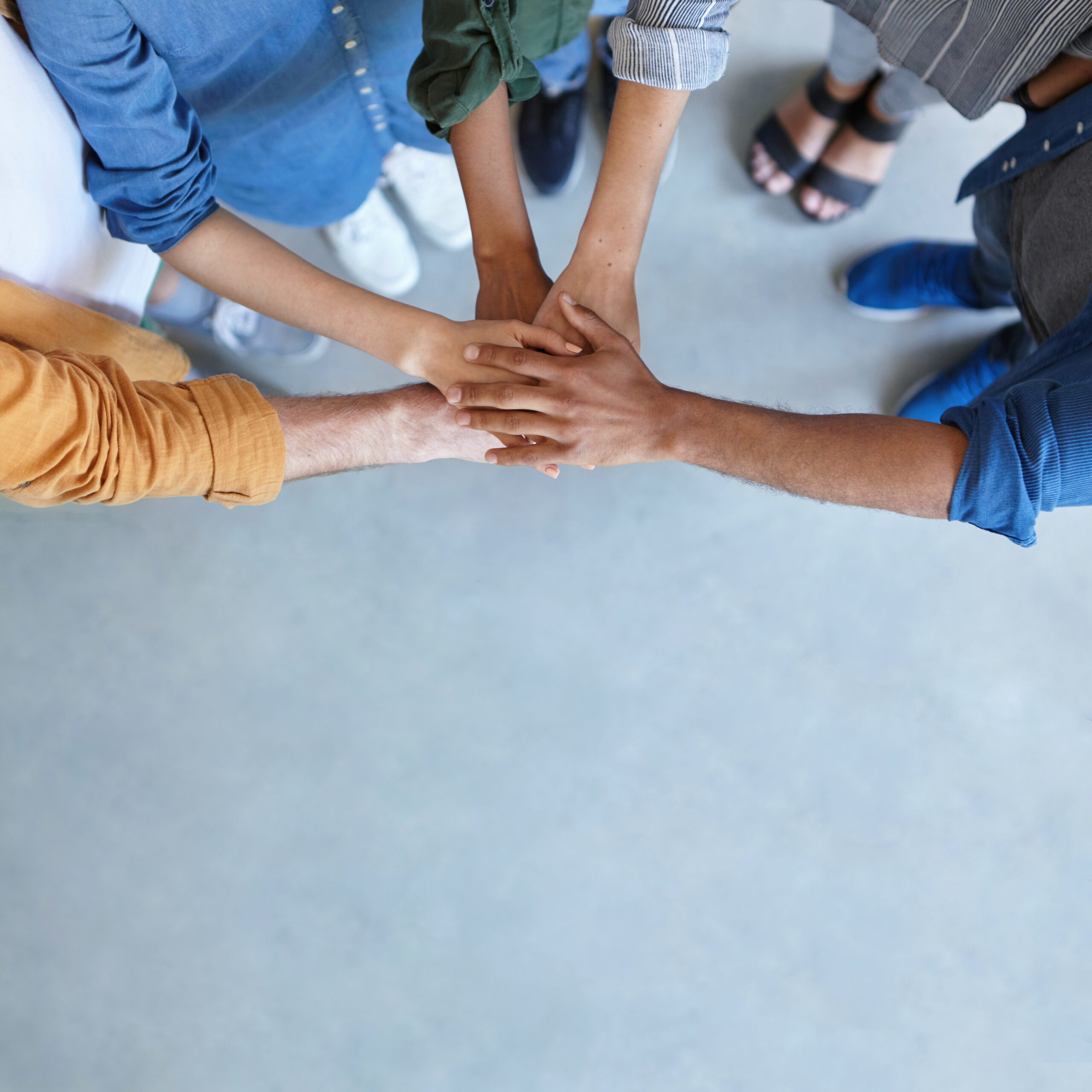 Friendship, partnership, togetherness, collaboration concept. Group of international friends stacking their hands expressing their friendship, agreement and support. People piling their hands